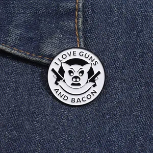 Detail of creative enamel pin with pig and guns logo pinned on blue denim fabric