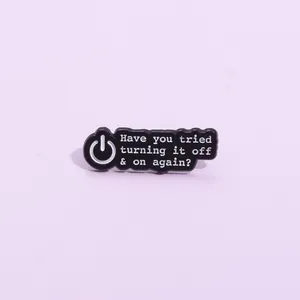 Pin's geek en émail noir avec icône d'alimentation et citation humoristique