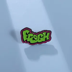 Detail der grünen Fresh-Emaille-Brosche mit rosa Konturen und kühnem Graffiti-Design