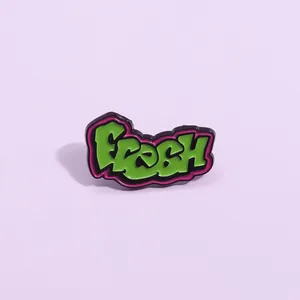 Makro-Detail der Fresh-Emaille-Anstecknadel mit grünem Finish und violettem Rand
