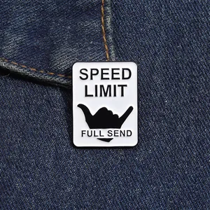 Vue macro du pin's émaillé SPEED LIMIT avec signe de la main Shaka sur du denim