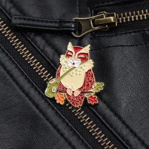 Detailed view of an owl messenger pin with a green bag on a black leather jacket