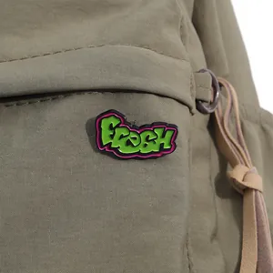 Detailansicht der grünen Fresh Emaille-Anstecknadel an einer olivgrünen Nylontasche