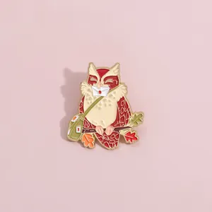 Detail of cute owl enamel pin with green letter bag and branch on pink background