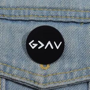 Enamel brooch with 'G > ^ V' symbol on blue denim jacket, representing highs and lows