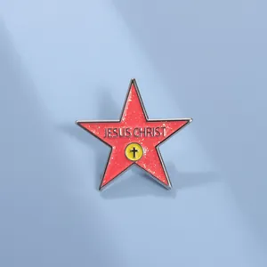 Macro detail of red glitter enamel star pin featuring Jesus Christ text and cross icon