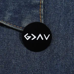 Macro shot of circular enamel brooch with God is Greater symbols on denim fabric