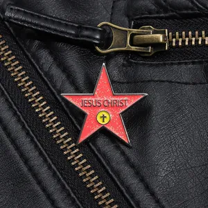 Macro shot of red glitter pentagram Jesus Christ enamel brooch on a black leather jacket