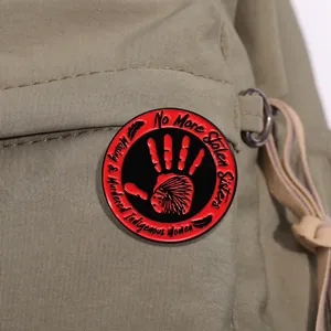 Détail d'un badge émaillé rond avec empreinte rouge sur sac en toile militaire