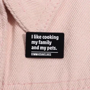 Détail d'un pin's en émail noir avec une citation pleine d'esprit sur denim rose