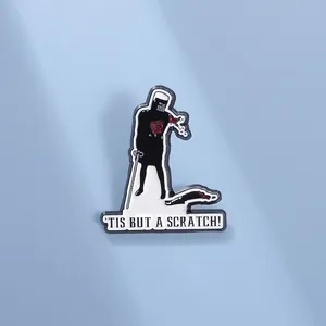 Λεπτομέρεια καρφίτσας ιππότη με τη φράση 'Tis But A Scratch' σε γαλάζιο φόντο