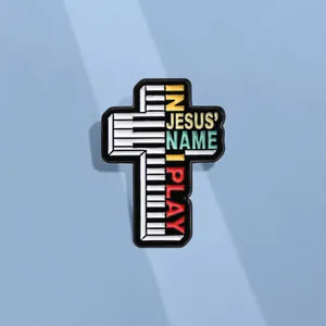 Détail macro du pin's en émail en forme de croix avec clavier et texte musical