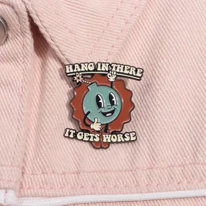 Detailed macro view of enamel pin with humor quote on pink denim jacket material