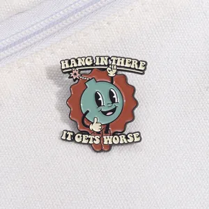 Detail of a cartoon bomb enamel pin featuring a sarcastic black humor text design
