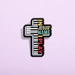 Pin's émaillé en forme de croix avec touches de piano et texte In Jesus Name I Play