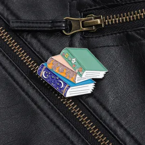 Detailed macro view of stacked fantasy book enamel pins on a black leather jacket
