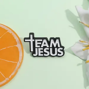 Enamel Team Jesus brooch pin with cross detail on light green aesthetic background
