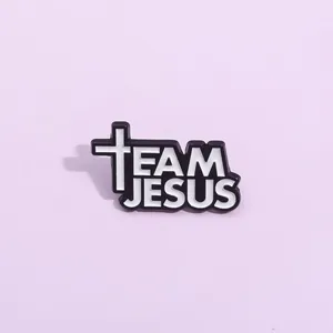 Detail of Jesus enamel pin with white cross and Team Jesus text on purple background