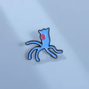 Detail shot of a cute blue enamel octopus pin with a pink button eye on light blue background