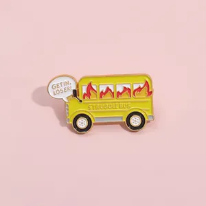 Detail showing enamel Struggle Bus brooch pin with Get In Loser quote on pink background