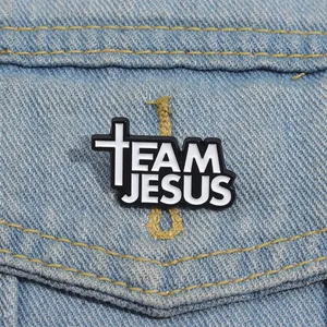 Detail of Jesus Enamel Pin with cross symbol on denim jacket for fashion style