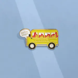 Detail of yellow enamel struggle bus pin with Get In Loser slogan on blue background