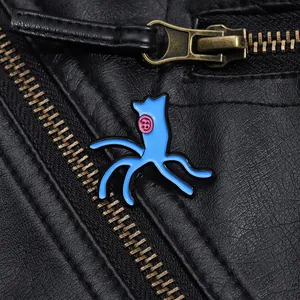 Detailed view of a blue octopus enamel pin with pink button eyes on a black leather jacket