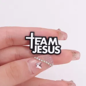 Close-up of Team Jesus shoe charm with white embossed letters and a cross icon