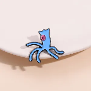 Detailed view of a blue cartoon monster enamel pin with five tentacles on a white ceramic plate
