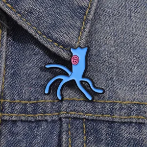 Close-up of Coraline ghost girl blue enamel pin with pink button on denim jacket