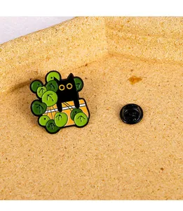 Macro shot of cartoon black cat hiding behind green leaves with butterfly clutch pin