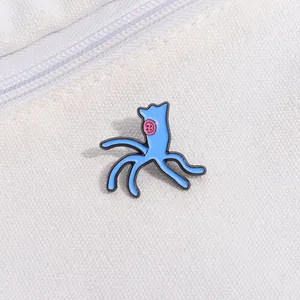 Macro detail of cartoon alien enamel pin with unique pink button eyes on canvas