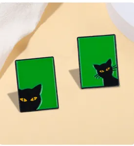 Détail de la broche chat en émail vert avec silhouettes noires et yeux jaunes