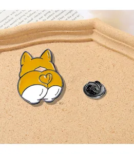 Macro view of cartoon corgi butt enamel brooch with heart detail and metal butterfly clutch