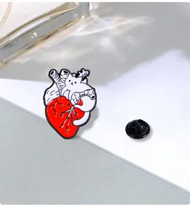 Macro shot of an anatomical heart enamel pin with a white cat detail and rubber back