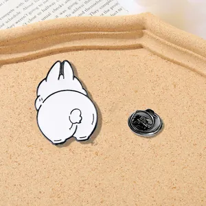 Detail of cute white rabbit enamel pin showing smooth metal finish and secure rubber back