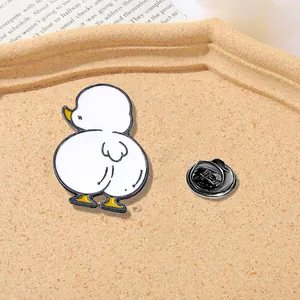 Detail of cute duck enamel pin with yellow webbed feet and black butterfly clutch back