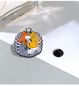 Detail of colorful enamel cat skeleton brooch with black butterfly clutch backing