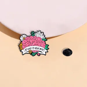 Emaille-Pin mit rosa Gehirn, Blumen und dem Be Kind To Your Mind-Schriftzug