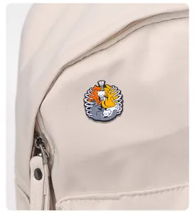 Close-up of cute enamel cat pins in a skeleton rib cage on a white canvas backpack