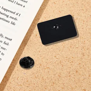 Detail view of the black enamel pin back with rubber clutch on a cork background