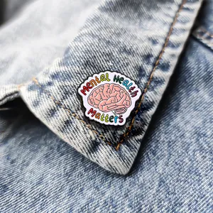 Spilla smaltata Mental Health Matters con cervello rosa e testo arcobaleno su denim