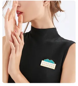 Detail van een emaille broche met Chinees gedicht op een zwart gebreid top