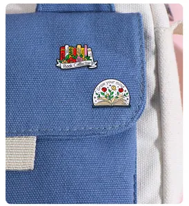 Detail of enamel book pins featuring Book Collector and Grow your mind text on a bag