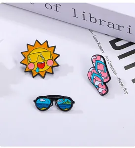 Detail of summer enamel pin set featuring cartoon sun, flip flops and sunglasses motifs