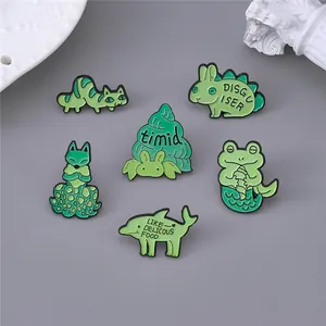 Set of six green enamel animal pins including rabbit, fox, and frog on grey background