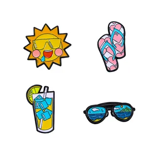 Detailed view of four summer-themed enamel pins including sun, flip-flops, drink and sunglasses