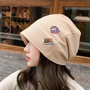 Beige ribbed knit beanie featuring Book Lover and Book Collector enamel pins detail