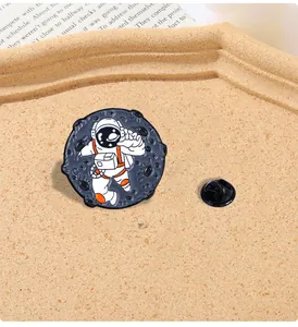 Gros plan détaillé d'un pin's astronaute circulaire en émail avec son attache au dos