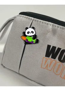 Detail of cute panda enamel pin attached to a grey canvas bag showing high quality craftsmanship